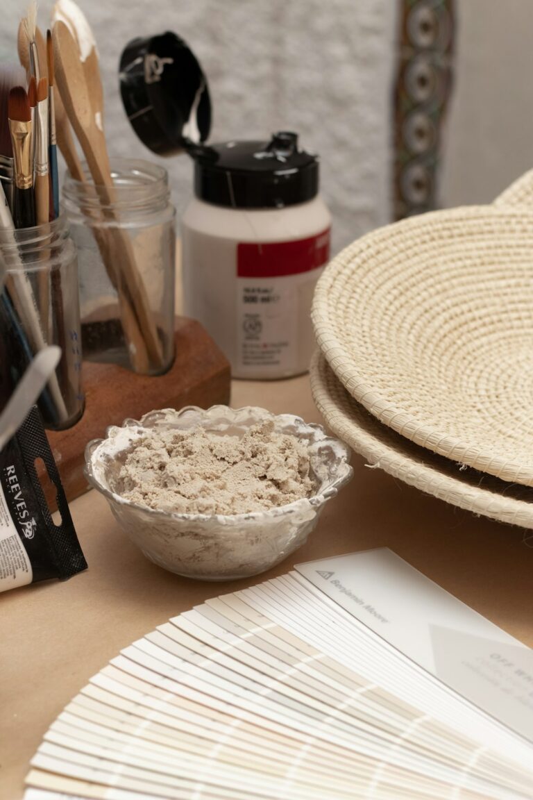 Homeowner comparing large paint samples beside a window, wood flooring, and neutral furnishings.